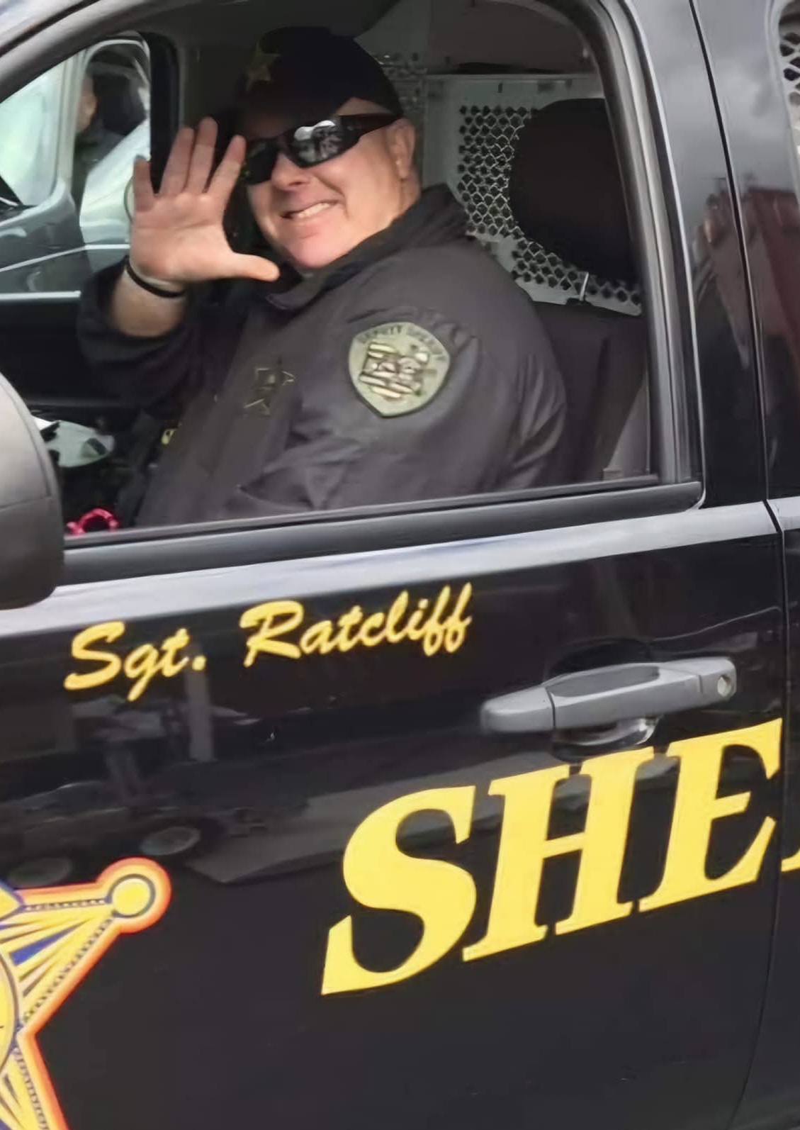Sgt. Ratcliff waving from a sheriff's cruiser